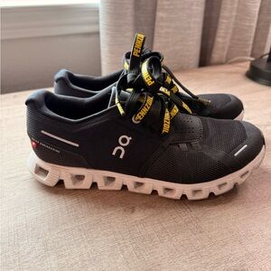 On Running Black Shoes with White and Yellow Accents